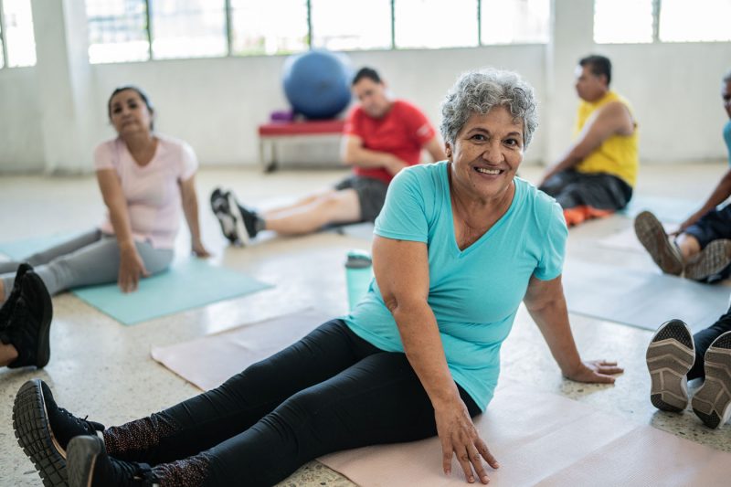 Portrait of senior woman stretching in a yoga class at a studio